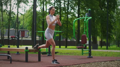 A-young-beautiful-woman-alone-performs-exercises-in-the-Park-in-the-summer-on-a-bench.-Healthy-lifestyle-and-sports-training-in-the-Park-in-summer.